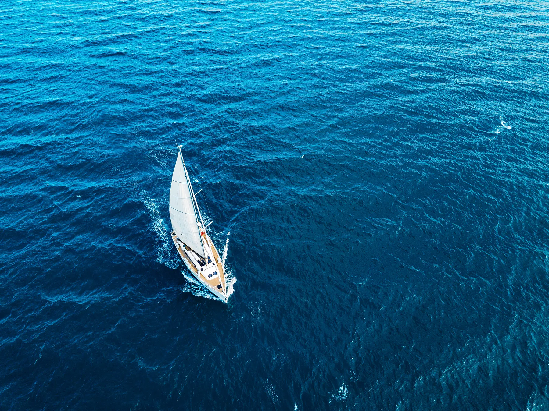 aerial-drone-view-of-a-white-yacht-with-a-white-sa-2025-07-21-19-23-08-utc