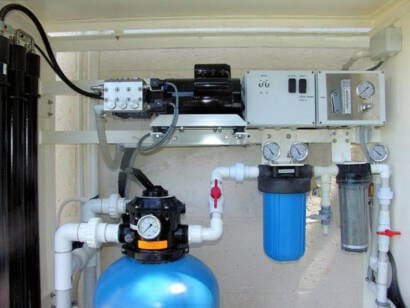 Compact Land-Based Watermaker with Pressure Tank ECHOTec wall-mounted home desalination system with blue pressure tank and filters